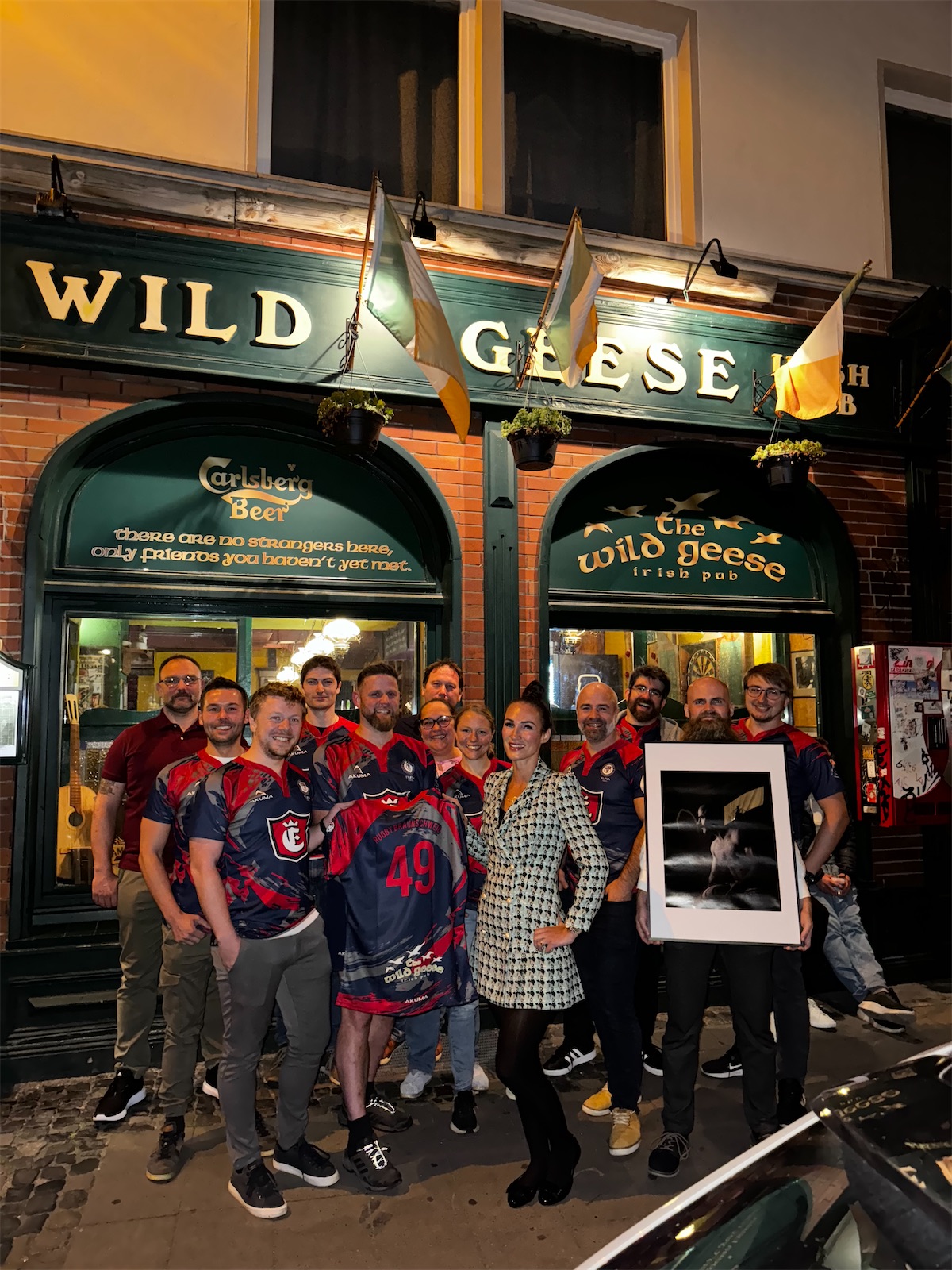 Das Team von Welfen Rugby Braunschweig in Trikots mit Wild-Geese-Logo vor dem Pub